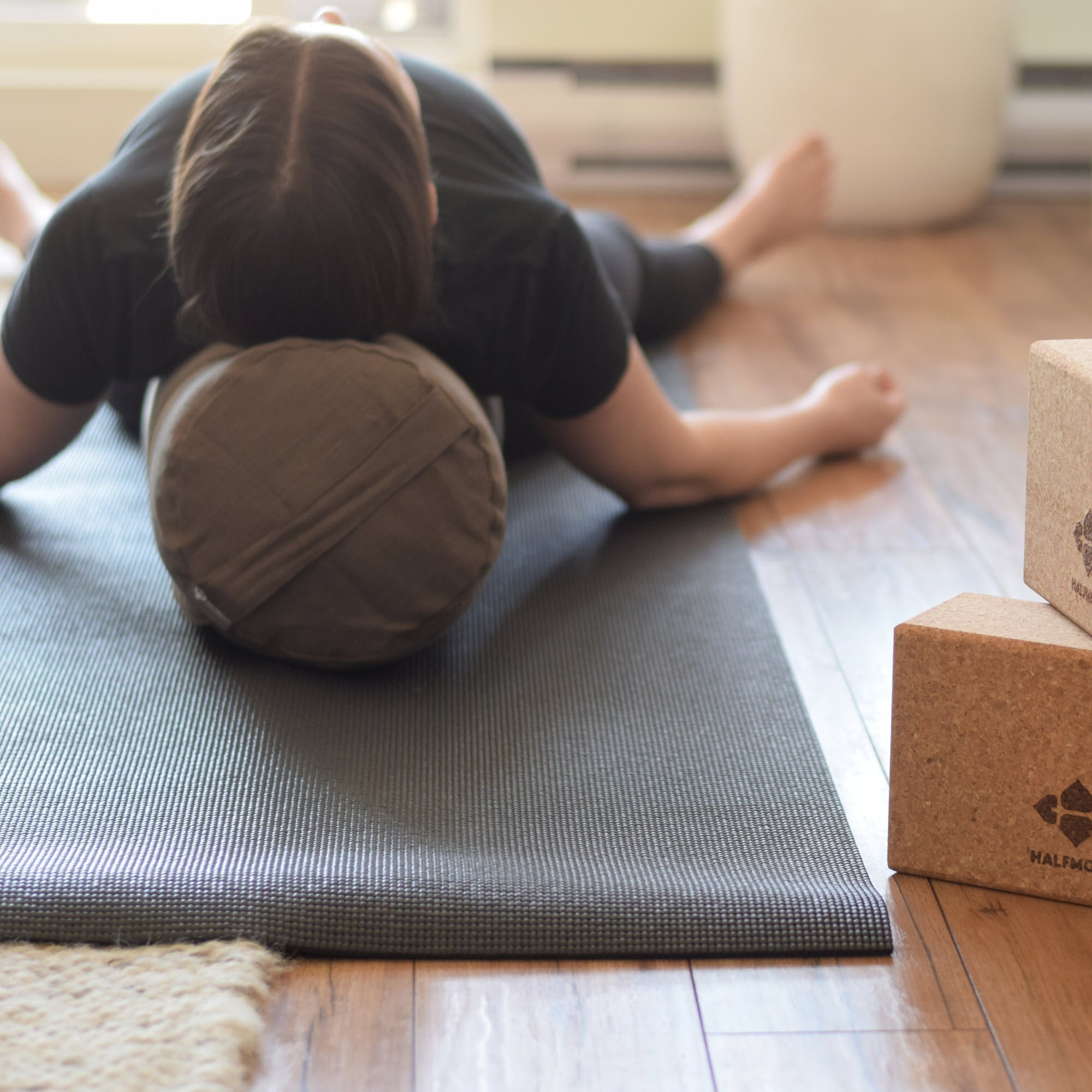 woman in savasana on the bolster